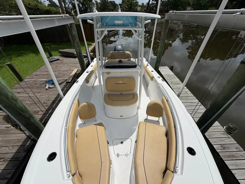 Slide: The Image of 2021 Sportsman Heritage 211 Center Console with beige seating, docked on calm water. - 45