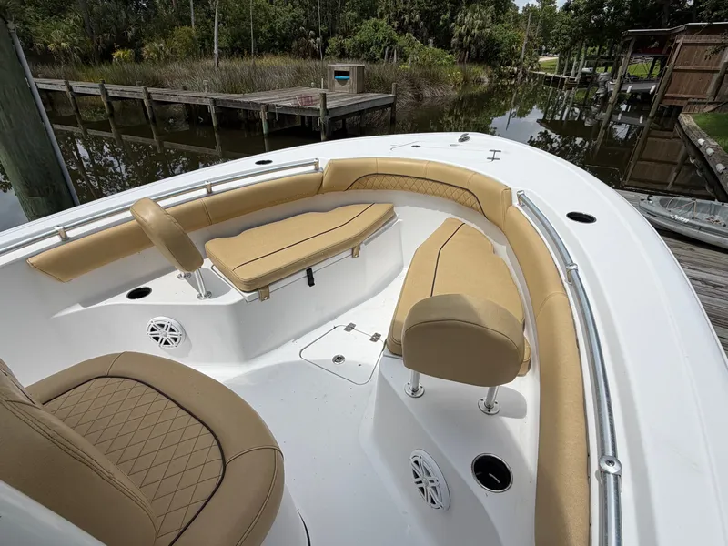 Slide: The Image of The image shows the bow of a Sportsman Heritage 211 Center Console boat with beige upholstery. - 47