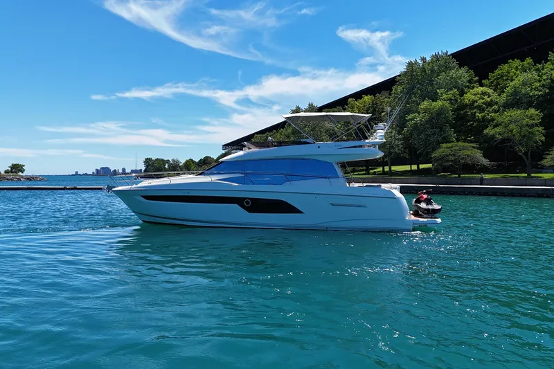 Slide: The Image of Luxury 2022 Prestige 520 yacht cruising on clear blue water under a sunny sky. - 10