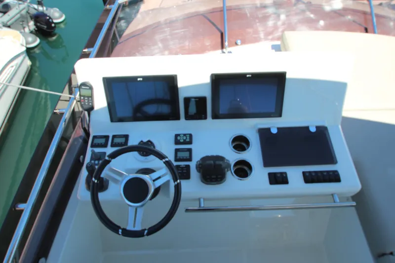 Slide: The Image of Control panel of a 2022 Prestige 520 yacht with dual screens and steering wheel. - 101