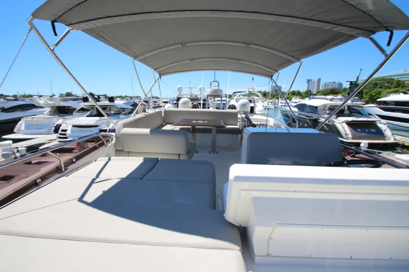 Slide: The Image of 2022 Prestige 520 yacht with spacious deck and canopy in marina setting. - 105