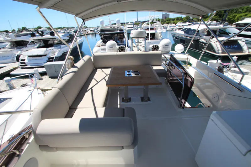Slide: The Image of Prestige 520 yacht 2022 model, featuring a spacious deck with seating and table at marina. - 106