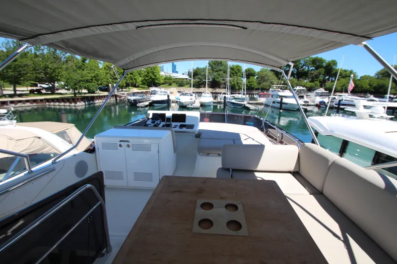 Slide: The Image of Prestige 520 yacht interior, 2022 model, docked in a marina with lush greenery. - 107