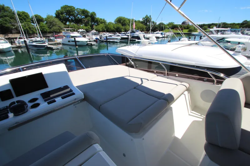 Slide: The Image of Prestige 520 yacht interior, 2022 model, featuring a spacious deck and modern controls in a marina. - 108
