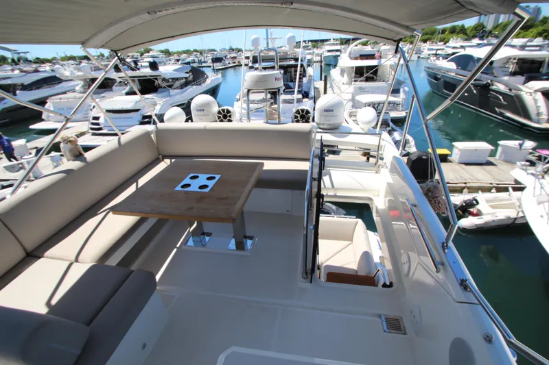 Slide: The Image of Luxurious 2022 Prestige 520 yacht interior with seating and table, docked at marina. - 110