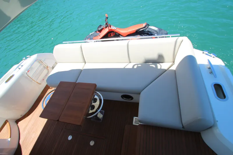 Slide: The Image of Luxury seating area on 2022 Prestige 520 yacht with watercraft in background. - 115