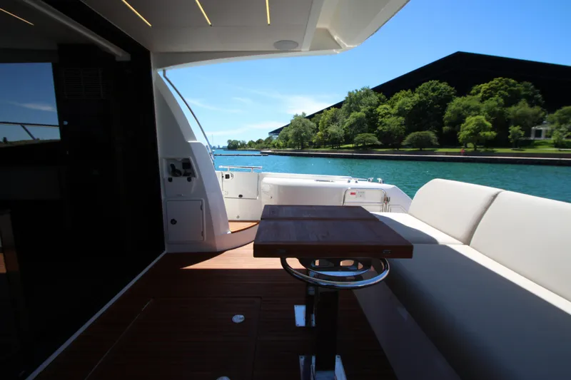 Slide: The Image of Luxury 2022 Prestige 520 yacht deck with seating and scenic waterfront view. - 117
