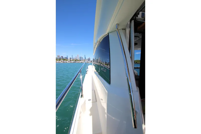 Slide: The Image of Side view of 2022 Prestige 520 yacht cruising near city skyline. - 119