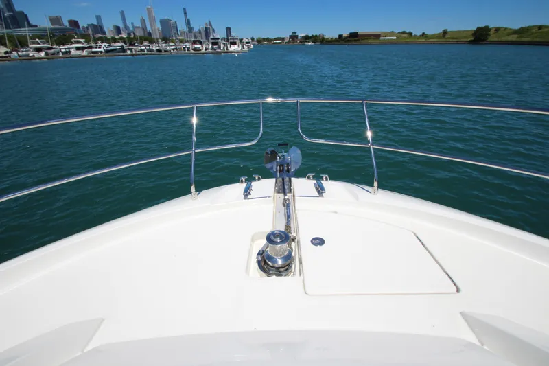 Slide: The Image of Bow view of 2022 Prestige 520 yacht on a sunny day, city skyline in background. - 121