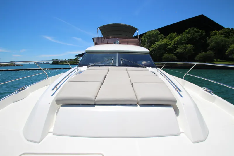 Slide: The Image of 2022 Prestige 520 yacht on water, featuring sleek design and sunbathing area. - 123