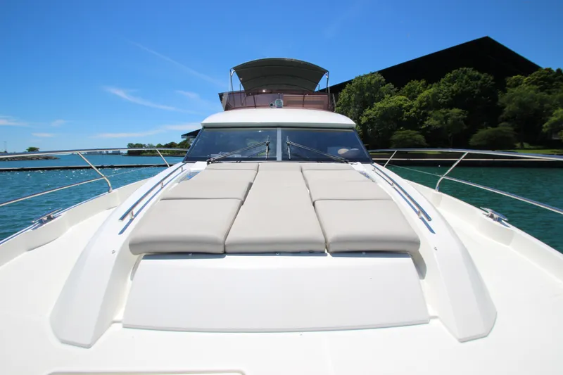 Slide: The Image of Luxurious 2022 Prestige 520 yacht on serene water, featuring spacious sunbathing deck. - 124