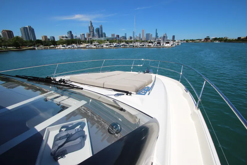 Slide: The Image of Prestige 520 yacht cruising near city skyline, 2022 model, clear blue sky and water. - 125