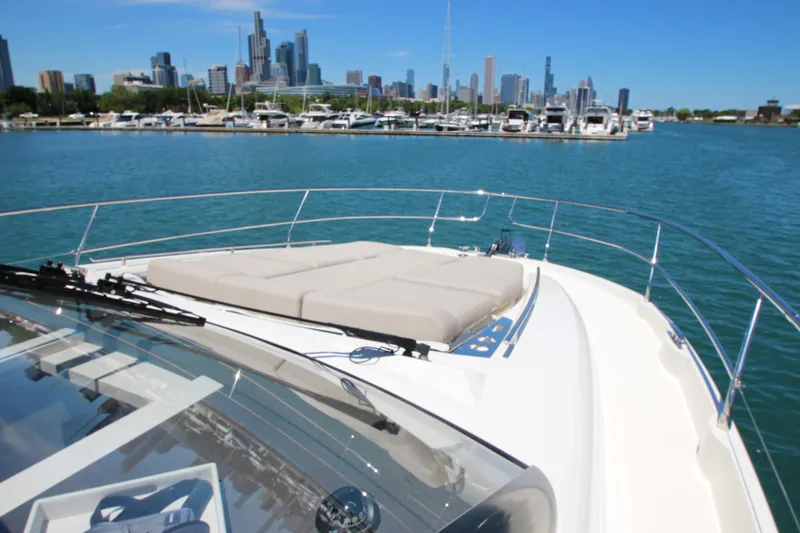 Slide: The Image of Luxury 2022 Prestige 520 yacht with city skyline and marina backdrop. - 126