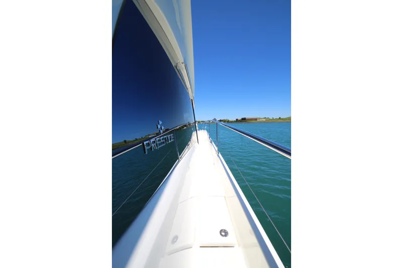 Slide: The Image of Side view of a 2022 Prestige 520 yacht cruising on clear blue water. - 127