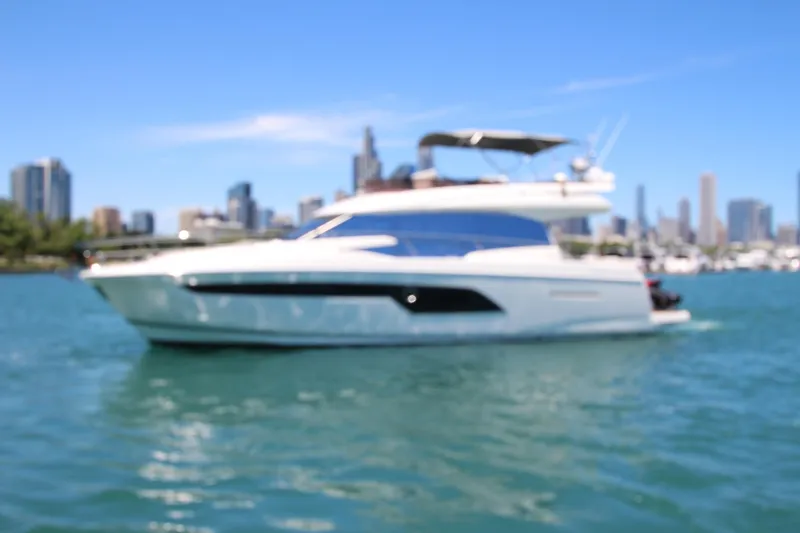 Slide: The Image of Blurry image of a 2022 Prestige 520 yacht on water with city skyline background. - 132