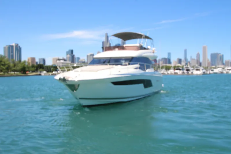 Slide: The Image of Luxury 2022 Prestige 520 yacht cruising near city skyline on a sunny day. - 138