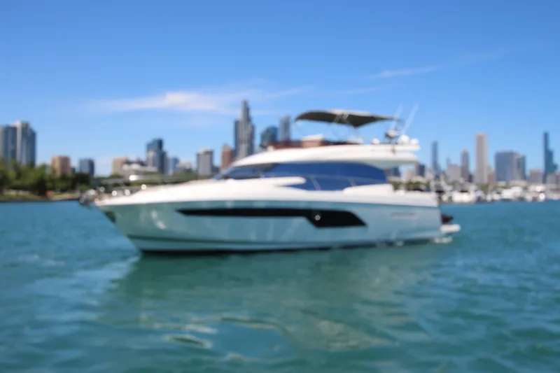 Slide: The Image of Luxury 2022 Prestige 520 yacht cruising near city skyline on a sunny day. - 139