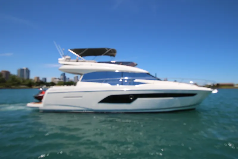 Slide: The Image of Blurry image of a 2022 Prestige 520 yacht on water under a clear blue sky. - 140