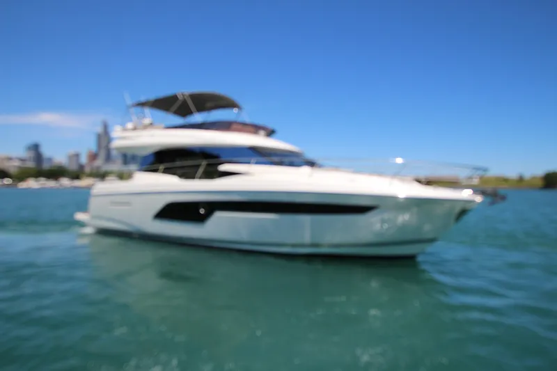 Slide: The Image of Blurry image of a 2022 Prestige 520 yacht on blue water under clear sky. - 141