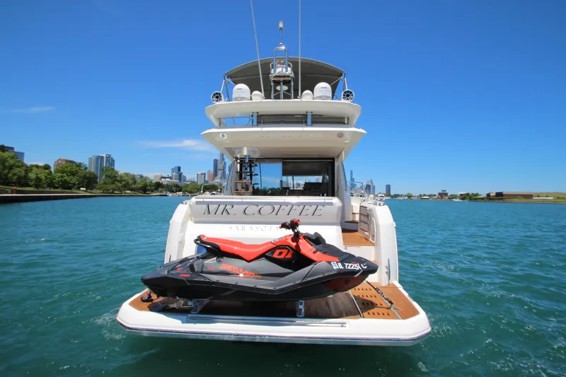 Slide: The Image of Luxury 2022 Prestige 520 yacht with jet ski on deck, cruising near city skyline. - 144