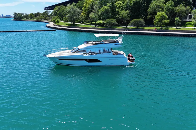 Slide: The Image of Luxury 2022 Prestige 520 yacht cruising on a serene, turquoise lake. - 3