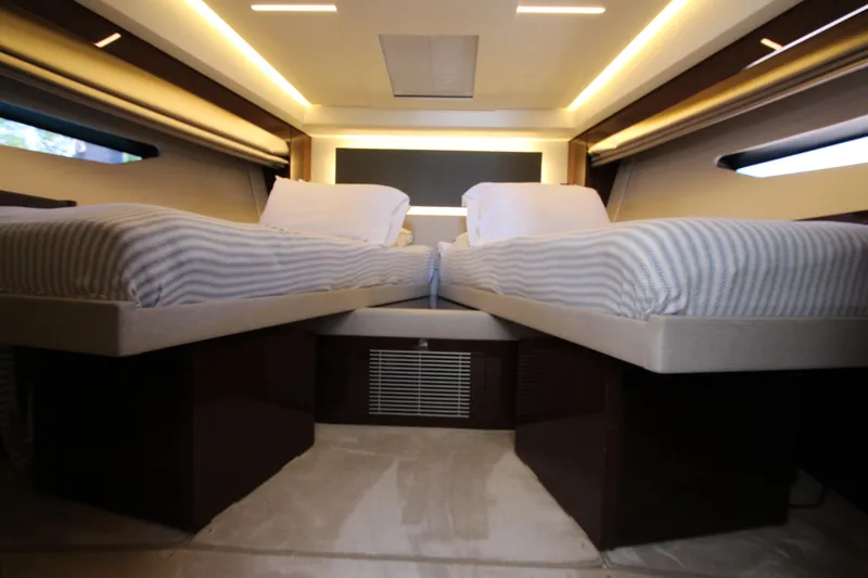 Slide: The Image of Luxurious twin beds in a 2022 Prestige 520 yacht cabin, featuring modern lighting and sleek design. - 50