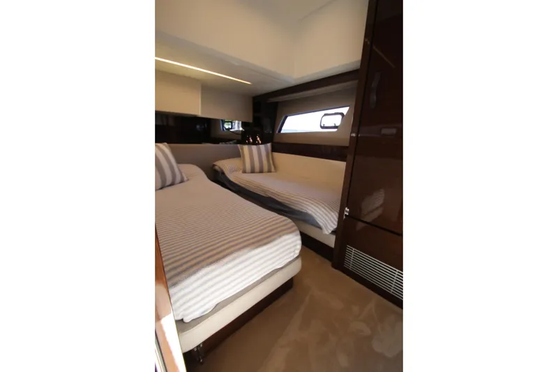 Slide: The Image of Luxurious twin cabin interior of 2022 Prestige 520 yacht with striped bedding. - 57