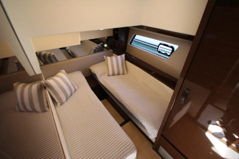Slide: The Image of Luxurious twin cabin interior of 2022 Prestige 520 yacht with striped bedding. - 58