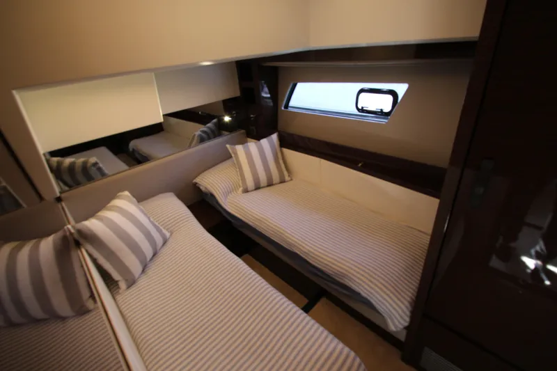Slide: The Image of Luxurious twin cabin interior of 2022 Prestige 520 yacht with striped bedding. - 59