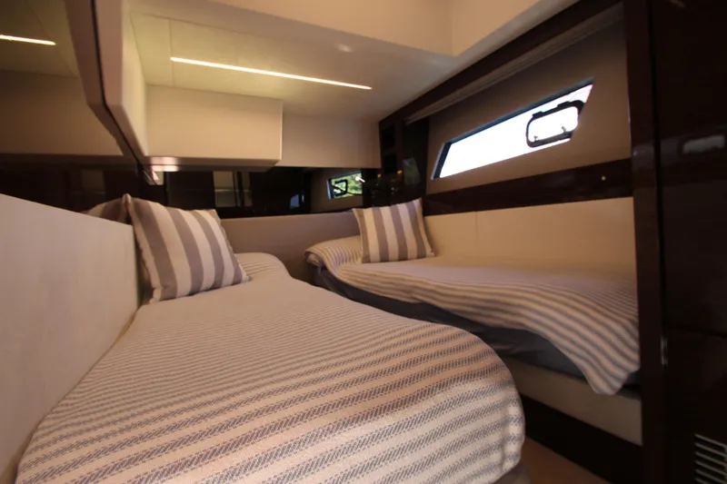 Slide: The Image of Luxurious twin cabin interior of 2022 Prestige 520 yacht with striped bedding. - 61