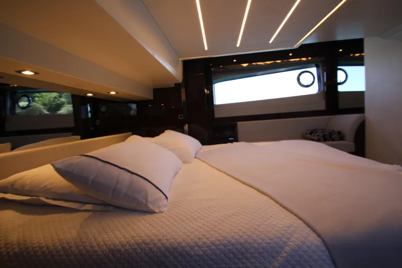 Slide: The Image of Luxurious bedroom interior of 2022 Prestige 520 yacht with modern lighting and elegant bedding. - 79
