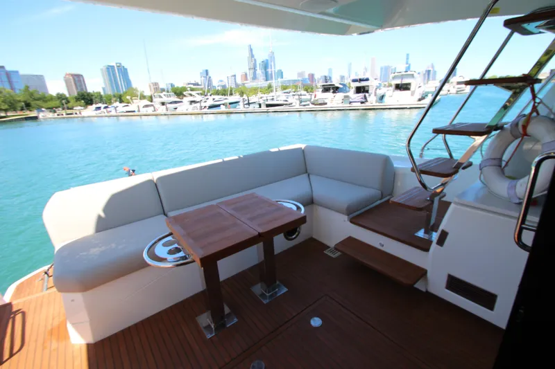 Slide: The Image of Luxury 2022 Prestige 520 yacht with elegant seating and scenic marina view. - 93