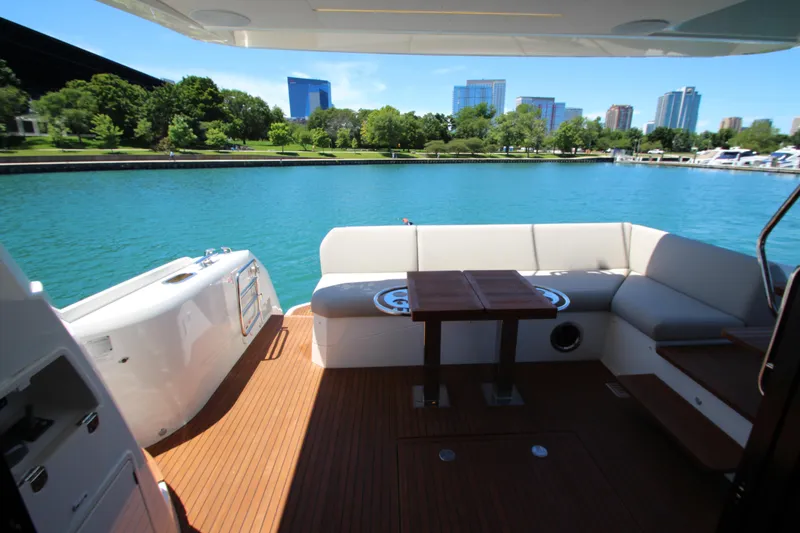 Slide: The Image of Luxurious 2022 Prestige 520 yacht deck with seating, overlooking serene waterfront and cityscape. - 94