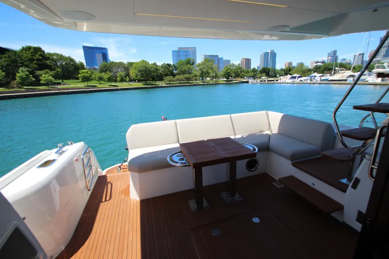 Slide: The Image of Luxurious 2022 Prestige 520 yacht deck with seating, overlooking a serene waterfront cityscape. - 97