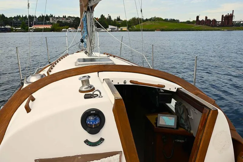 Slide: The Image of 1977 Mercator Offshore sailboat on calm water, featuring wooden deck and navigation equipment. - 7