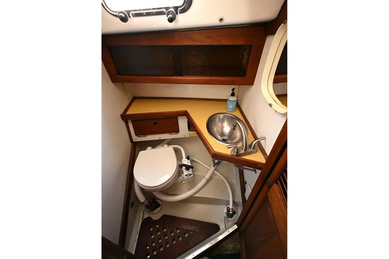 Slide: The Image of 1977 Mercator Offshore boat bathroom with sink, toilet, and wooden cabinetry. - 15