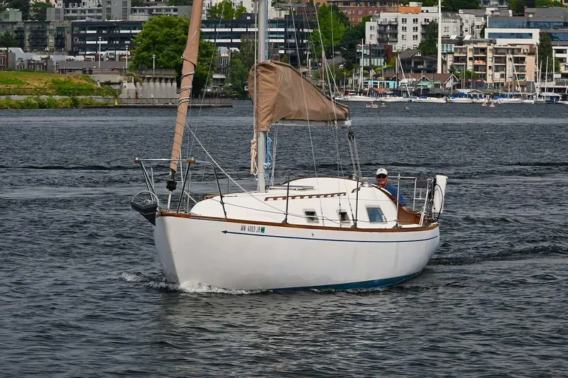 Slide: The Image of 1977 Mercator Offshore sailboat cruising on a scenic urban waterway. - 2