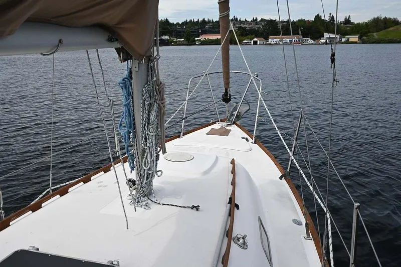 Slide: The Image of 1977 Mercator Offshore sailboat deck with ropes and mast on calm water. - 8