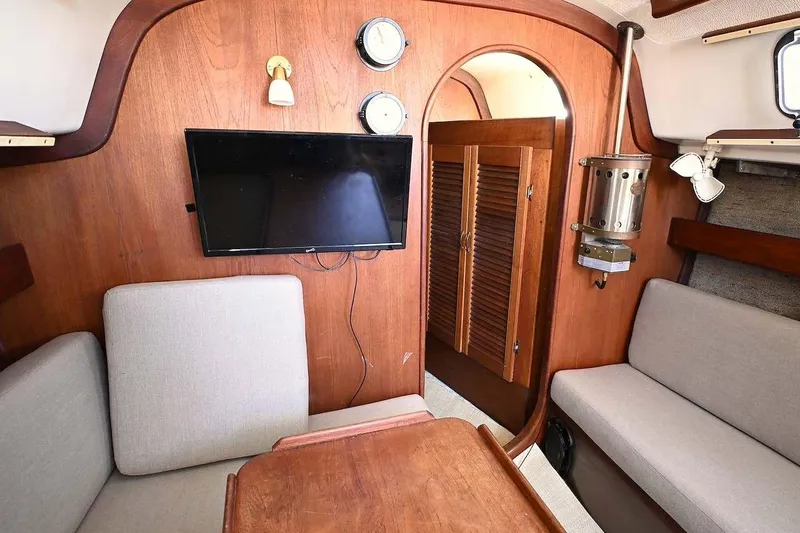Slide: The Image of Interior of 1977 Mercator Offshore boat with wood paneling, seating, and a mounted TV. - 16