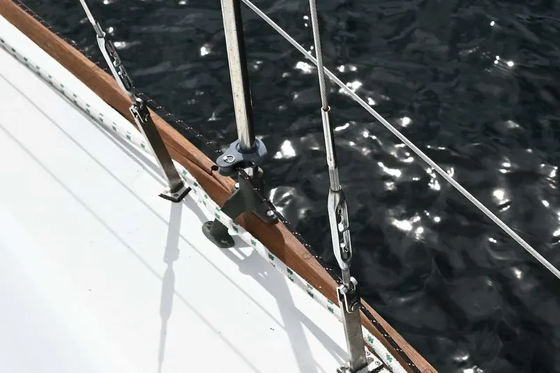 Slide: The Image of Close-up of 1977 Mercator Offshore sailboat rigging over shimmering water. - 11
