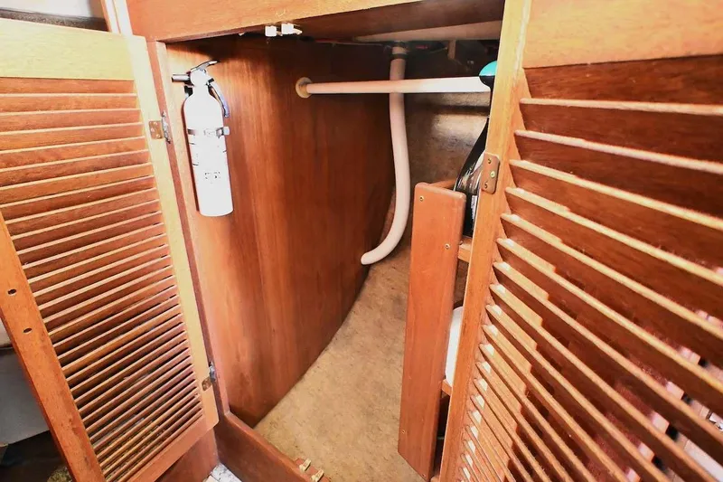 Slide: The Image of 1977 Mercator Offshore boat interior with wooden cabinetry and fire extinguisher. - 20