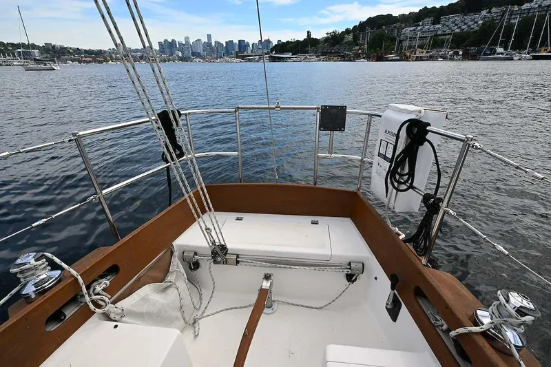 Slide: The Image of 1977 Mercator Offshore sailboat deck with city skyline and marina in the background. - 4