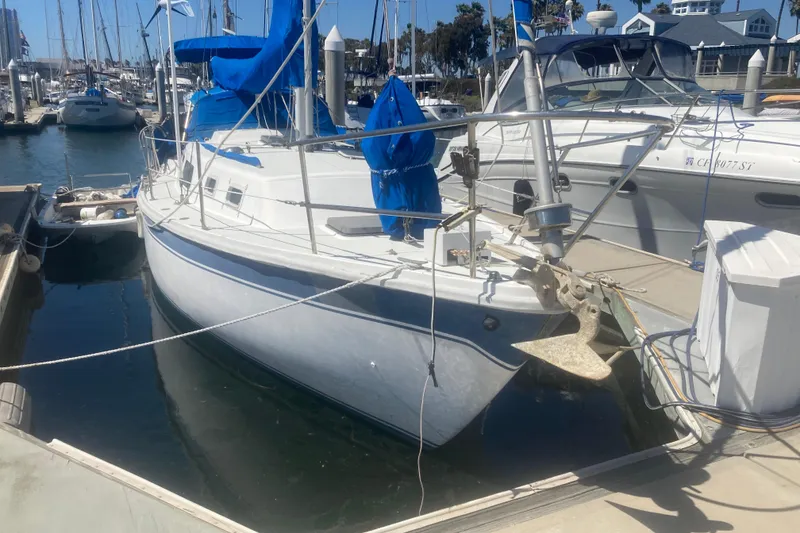 The Image of 1979 CAL 34-III sailboat docked in marina, featuring blue sails and white hull. - 0
