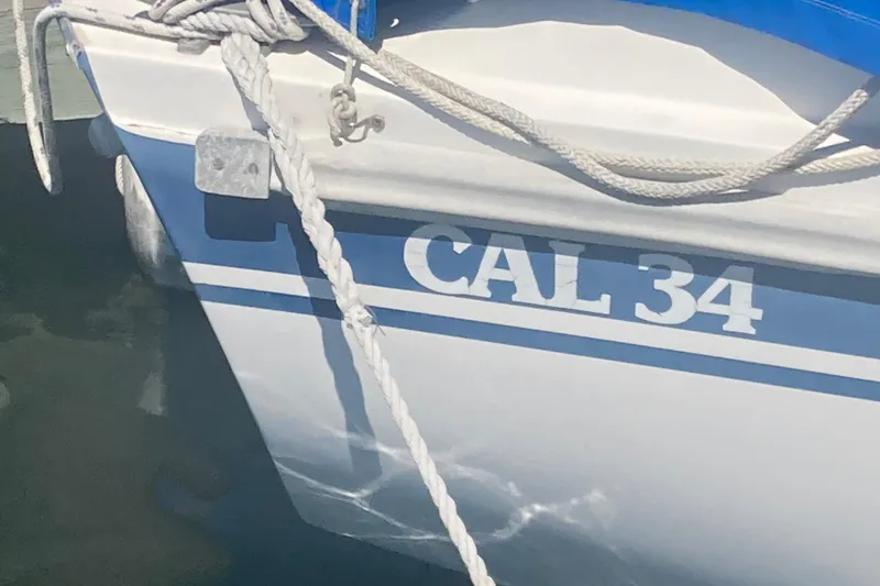 Slide: The Image of 1979 CAL 34-III sailboat docked, featuring blue and white hull with visible ropes. - 13