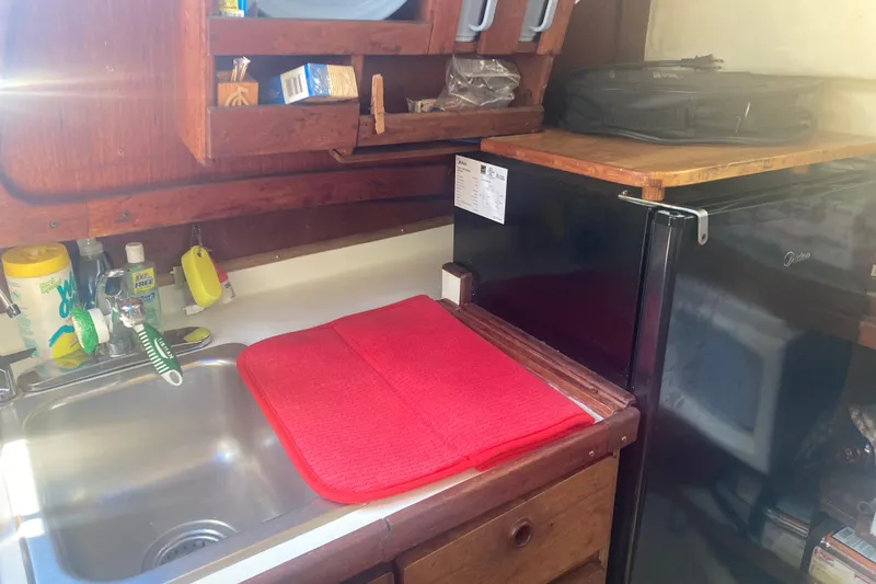 Slide: The Image of Small kitchen area in a 1979 CAL 34-III sailboat with sink and mini fridge. - 15