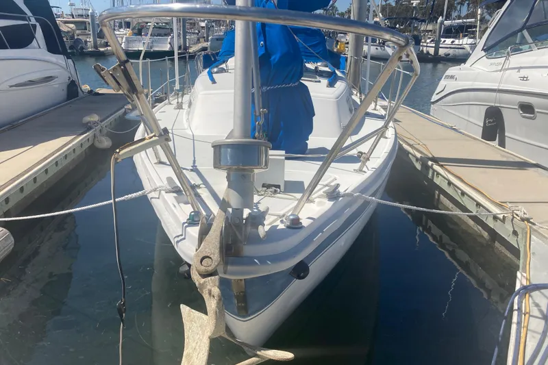 Slide: The Image of 1979 CAL 34-III sailboat docked at marina, front view with anchor visible. - 3
