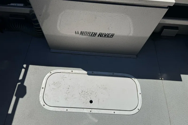 Slide: The Image of 2011 North River 21' Seahawk boat interior with storage compartment and logo. - 18