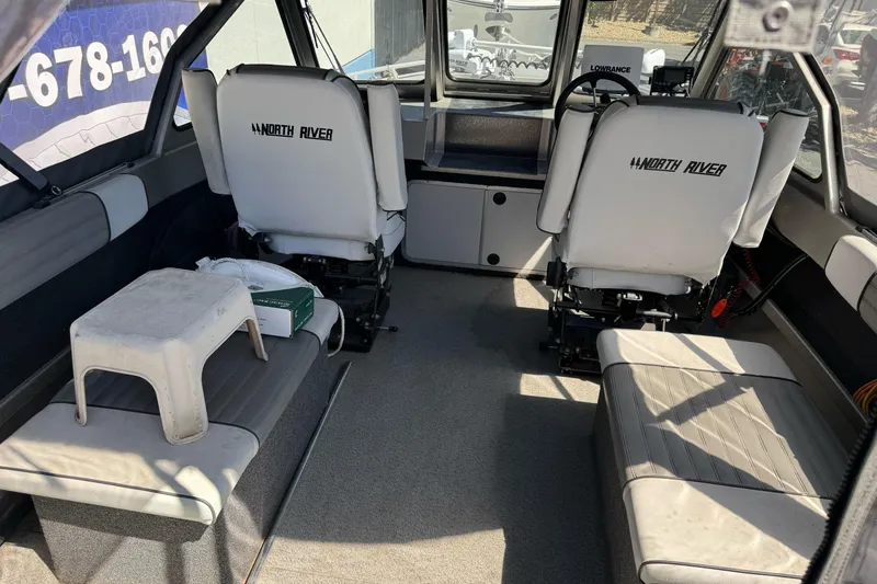 Slide: The Image of Interior of a 2011 North River 21' Seahawk boat with seating and steering console. - 21