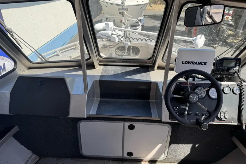 Slide: The Image of Interior view of a 2011 North River 21' Seahawk boat cockpit with steering wheel and navigation equipment. - 22