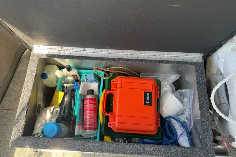 Slide: The Image of Storage compartment in a 2011 North River 21' Seahawk boat with various supplies and tools. - 23